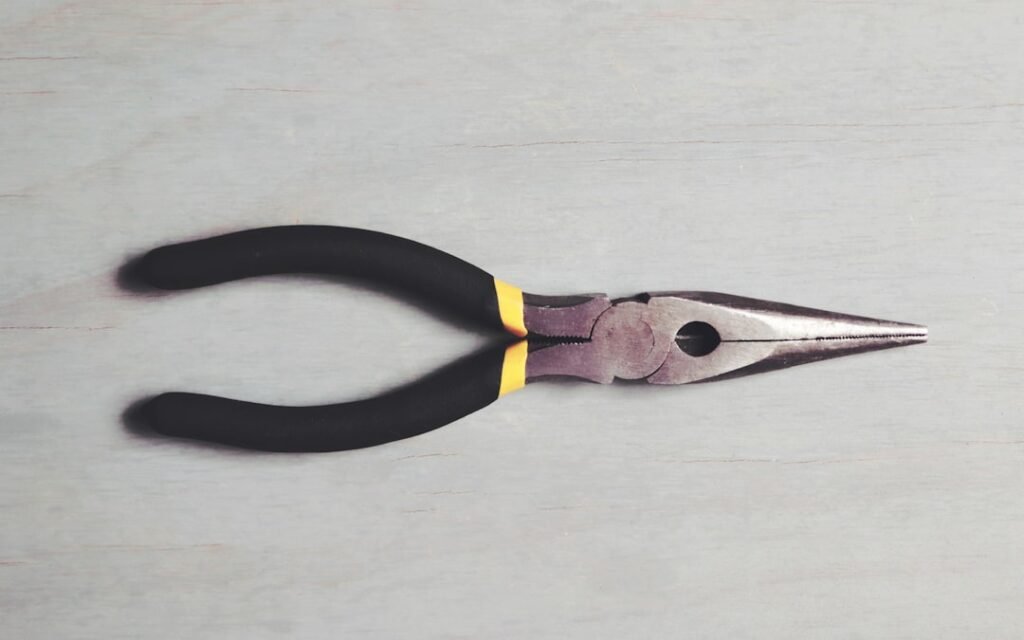 Um Par De Alicates Pretos E Amarelos Em Uma Superficie Branca MOYtZNqNtTU