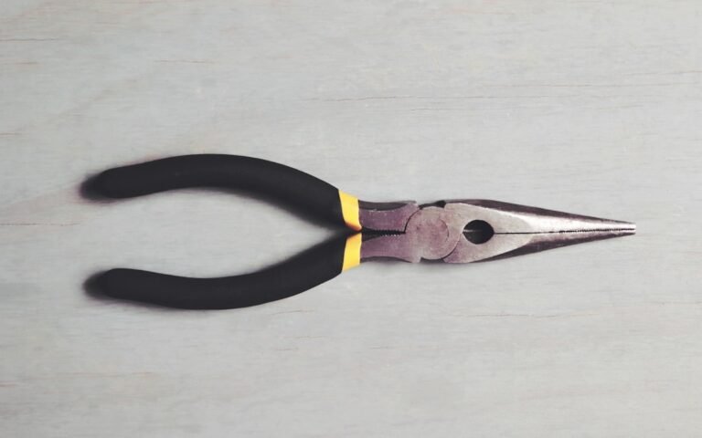 Um Par De Alicates Pretos E Amarelos Em Uma Superficie Branca MOYtZNqNtTU