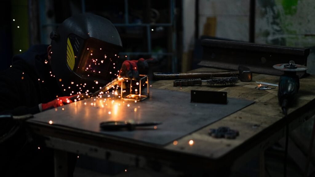 Um Homem Em Uma Mascara De Solda Trabalhando Em Um Pedaco De Metal YHiSOZ4bqUc