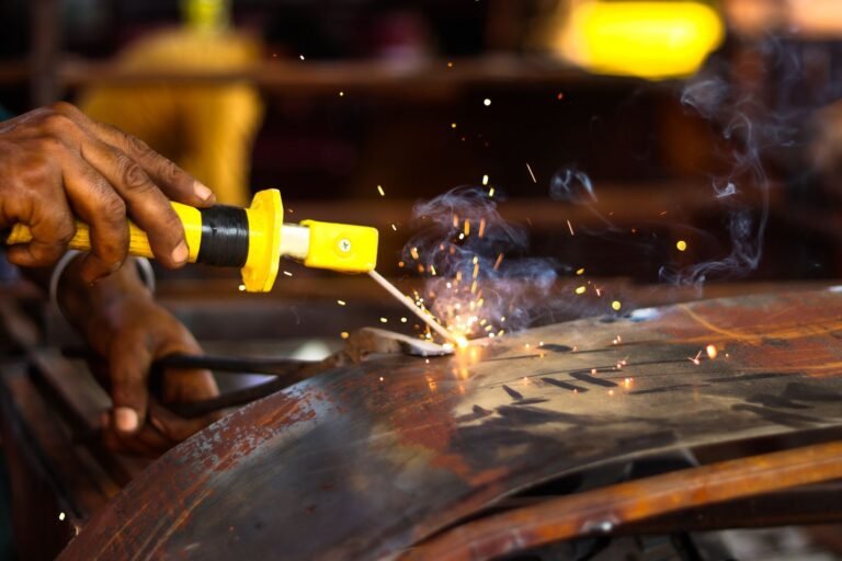 Detailed view of welding and sparks flying in a workshop setting, showcasing precision and craftsmanship.