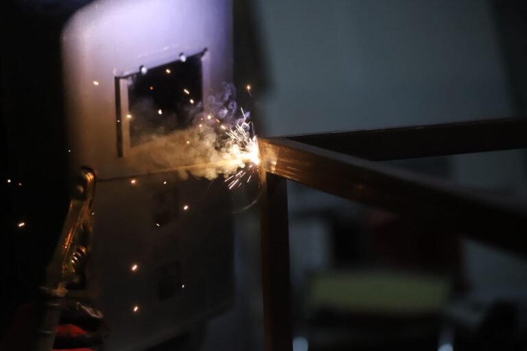 Close-up of welding sparks flying during a metalwork process indoors.